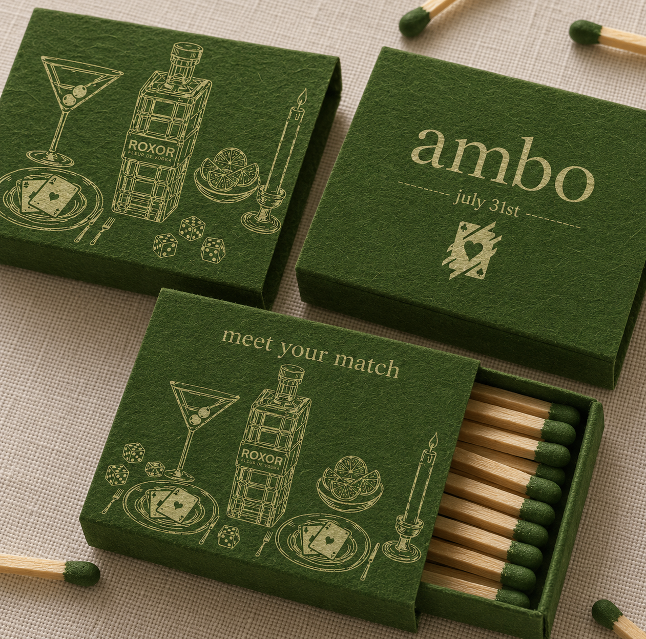 Two hands holding playing cards across a green velvet bistro table with a candle and cocktail